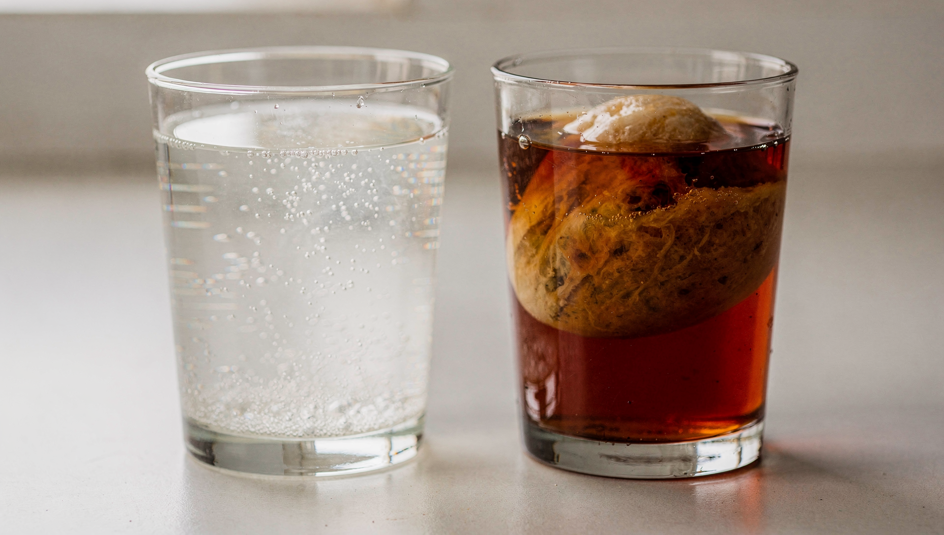 Wasserkefir und Kombucha Vergleich - zwei Gläser mit fermentierten Getränken nebeneinander